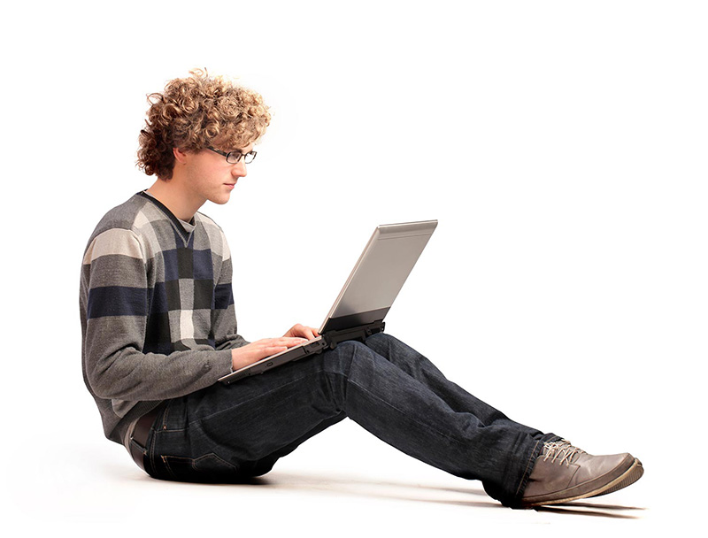 young man sitting on floor with laptop on his knees depicting browsing Get Resume Help packages